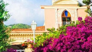A building with a traditional architectural style, featuring a prominent archway and a balcony. - Villa Cheta Hotel & Restaurant (Maratea)