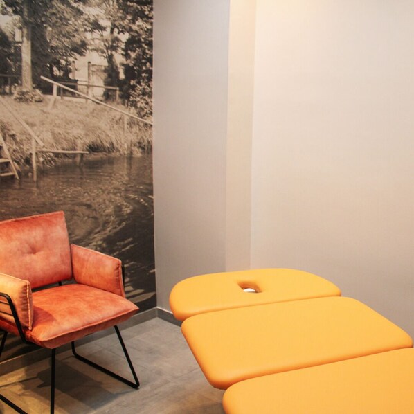 A room with a vintage poster, a red leather chair, and an orange bench. - Ratskeller Wiedenbrück (Rheda-Wiedenbruck)
