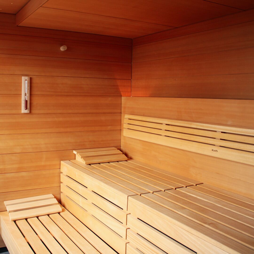 Una sauna con bancos de madera y diseño de bancos ranurados.
