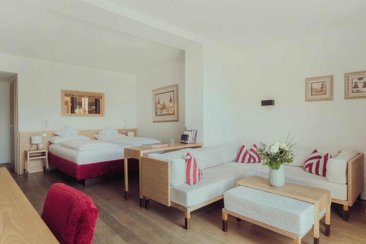 Una habitación de hotel con una cama, un escritorio, un sofá y una mesita.