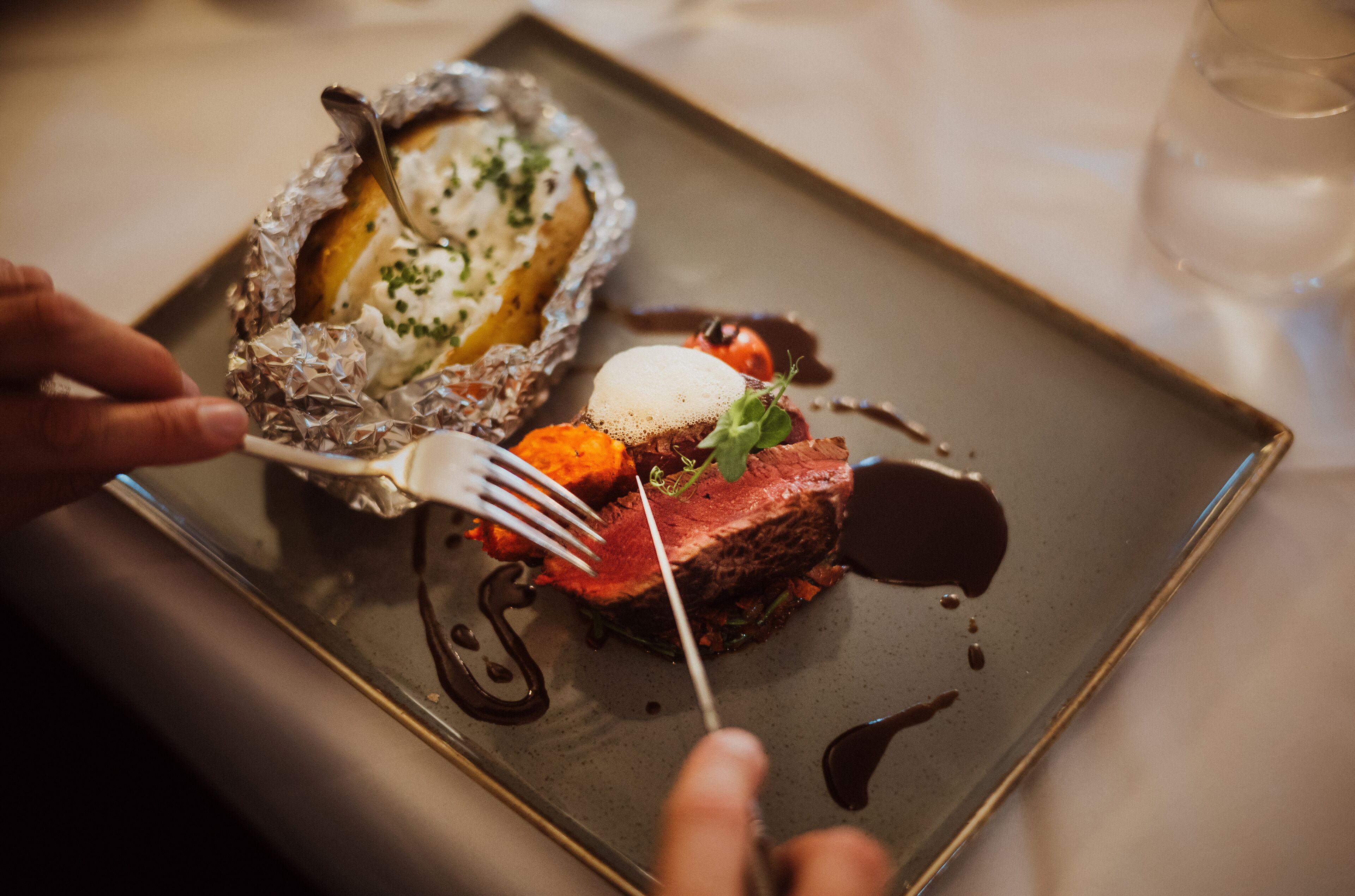 Un plato con carne, verduras y salsa.
