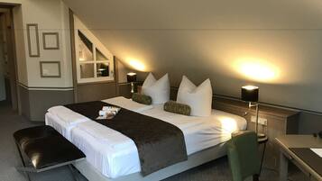 A hotel room with a large bed, two bedside tables, a desk, and a chair.