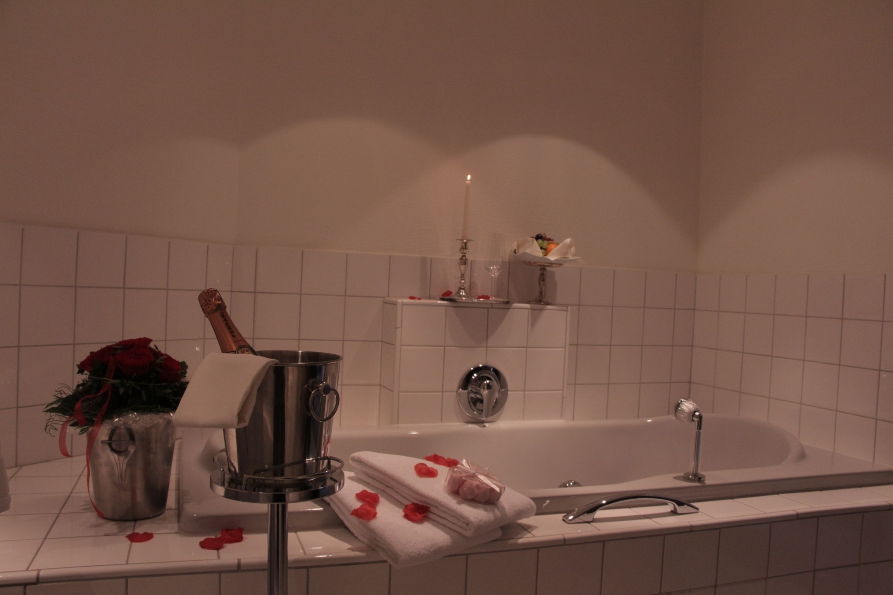 A bathroom with a bathtub, a shower, a vanity with a mirror, and a towel rack.