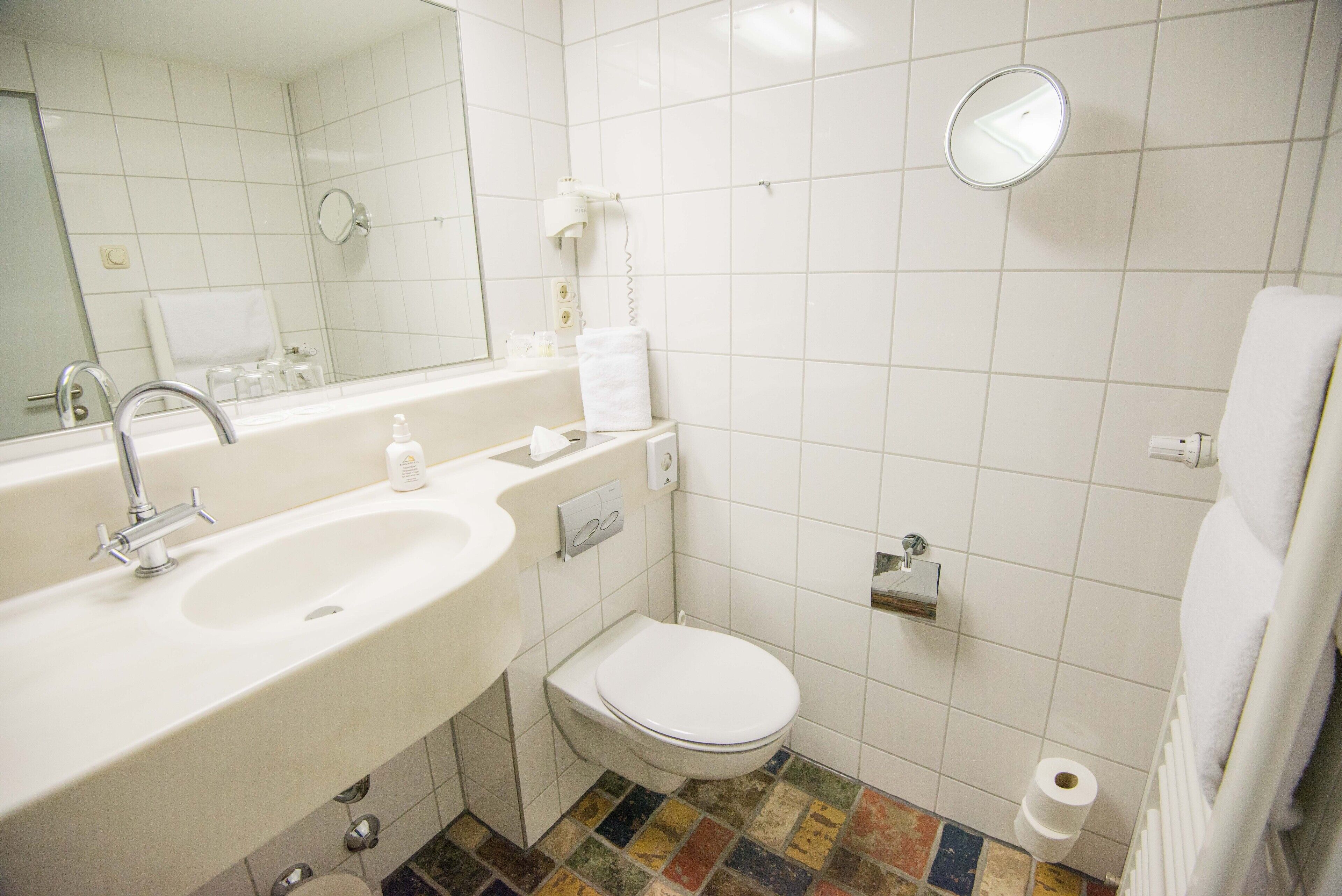 Kylpyhuone, jossa on pesuallas, wc ja peili.