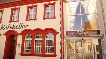 A building with a sign reading "Ratskeller" and another sign for "Hotel".