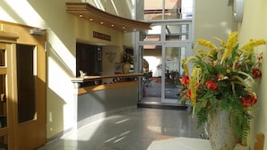 A reception area with a reception desk, a clock, and a large window. - Bed & Breakfast zum alten Ratskeller (Vetschau/Spreewald)