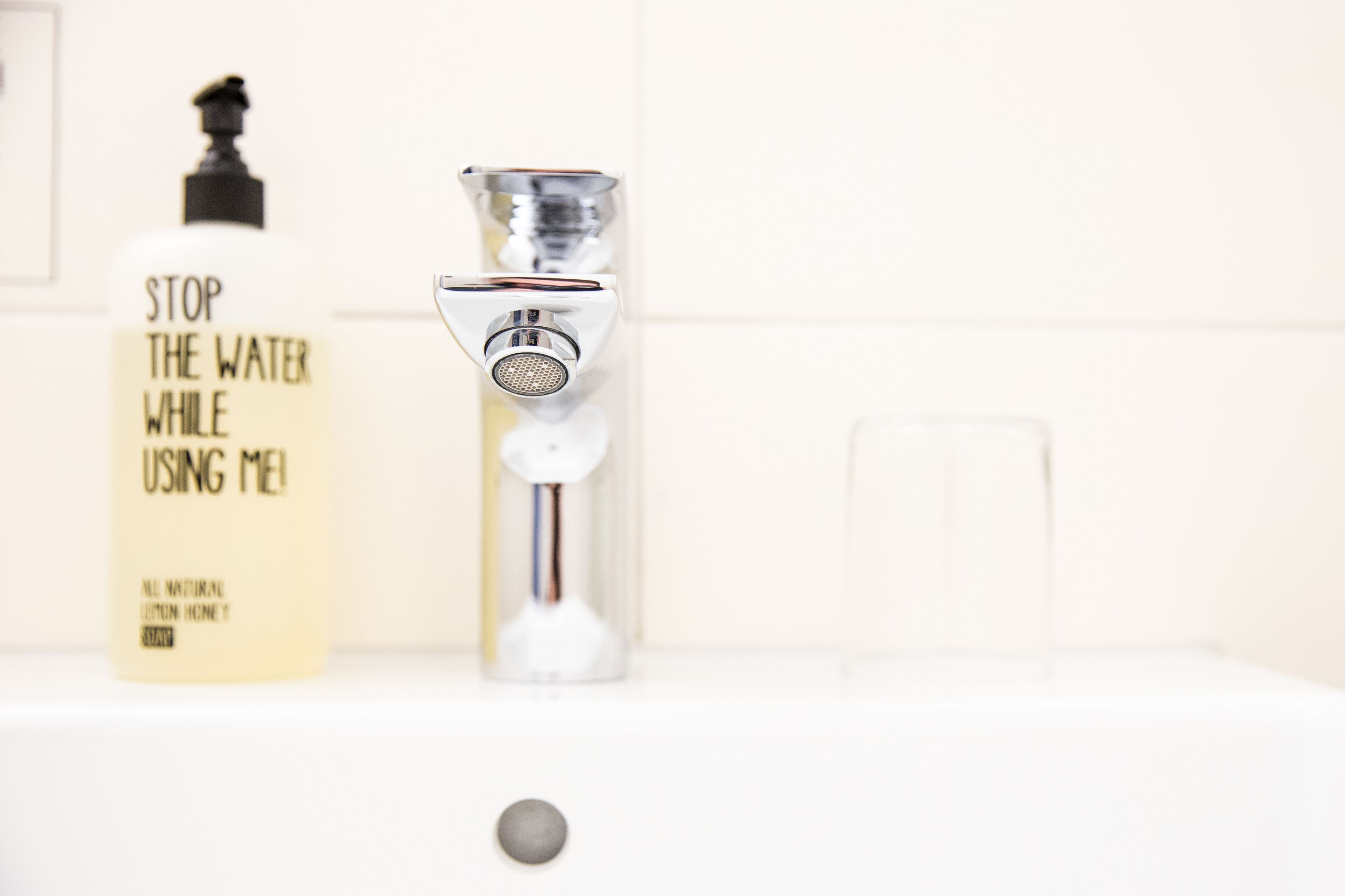 Un baño con una botella de loción y un grifo.
