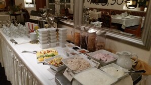 Una mesa de buffet con diversos alimentos y utensilios.