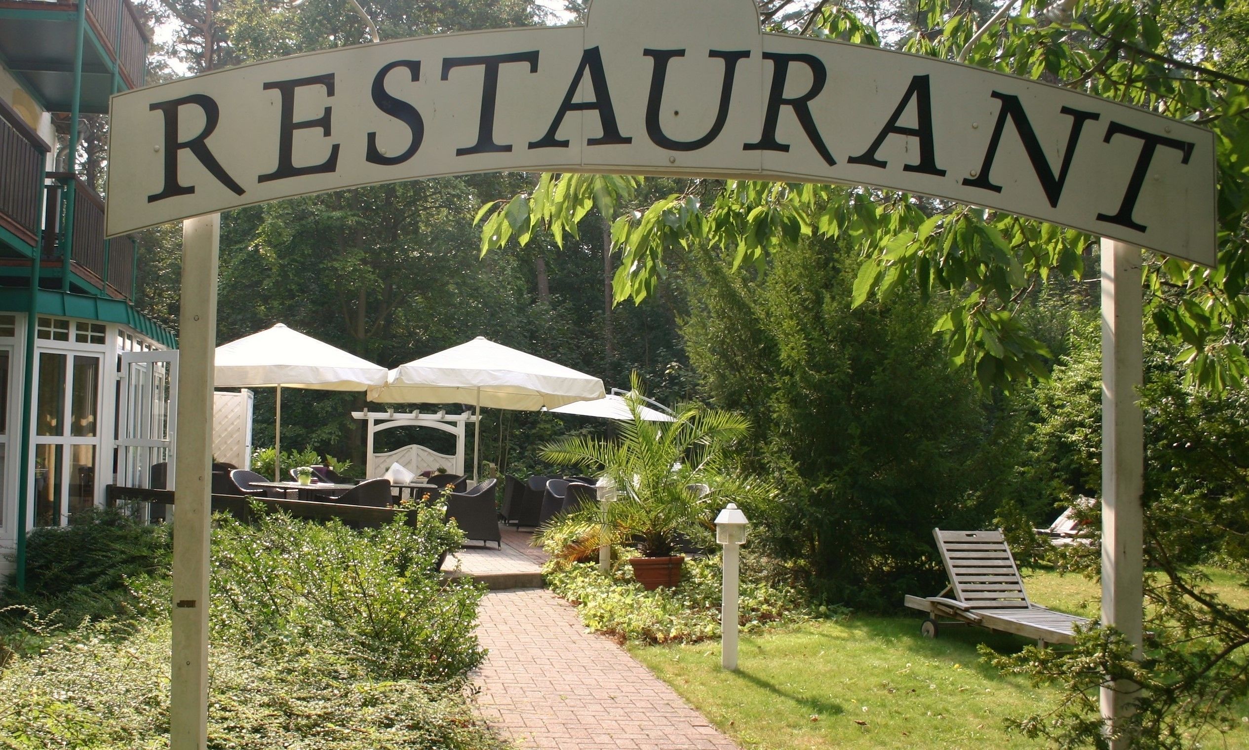 Uma área de restaurante ao ar livre, com uma placa indicando 