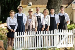 A group of people standing in front of a white picket fence. - Bokel-Mühle am See (Bokel)