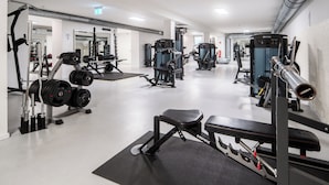 A gym with weightlifting equipment, treadmills, and exercise machines.
