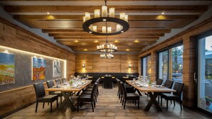 Un comedor amplio con mesas largas, lámparas modernas y paneles de madera.