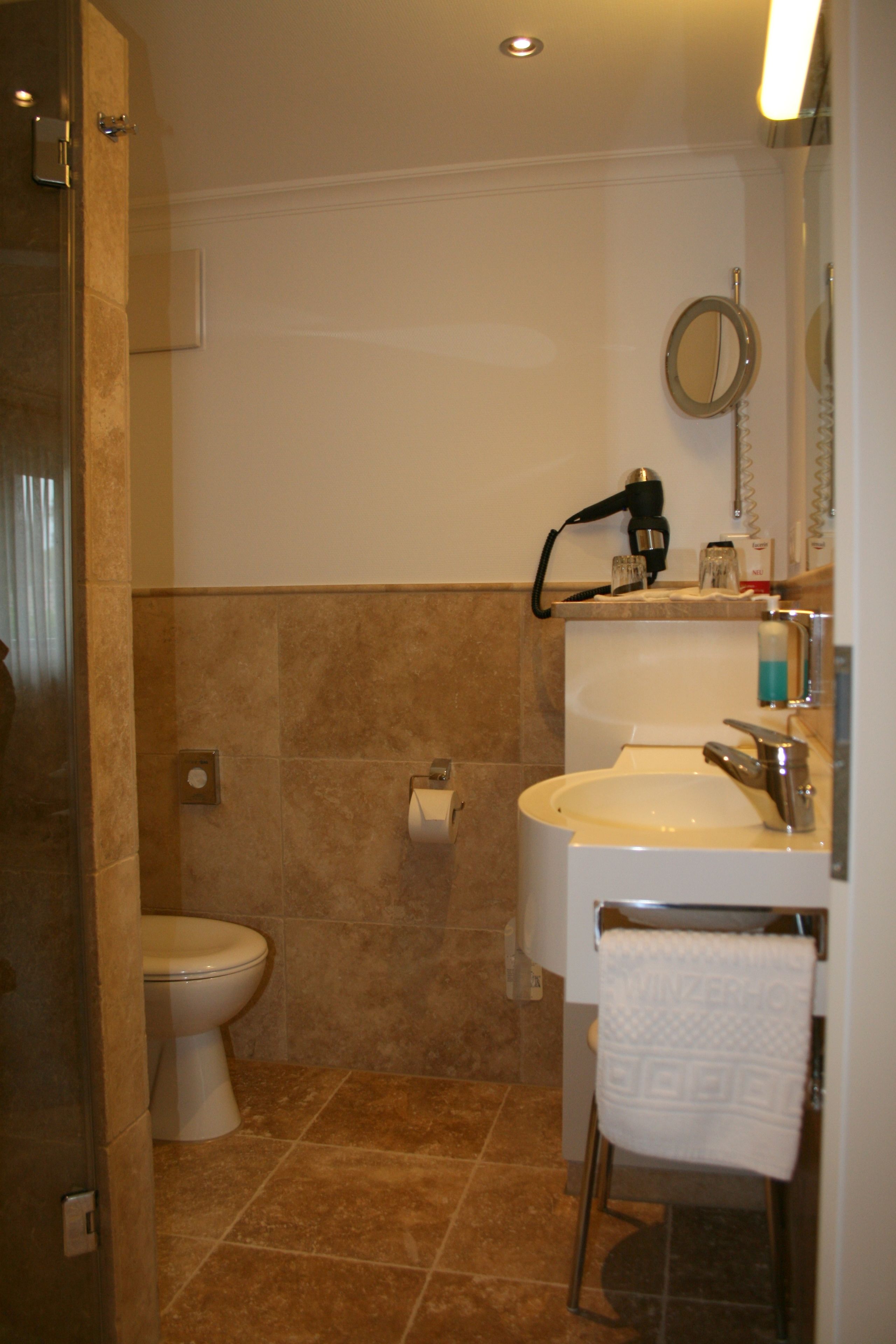 Un baño con inodoro, lavabo y espejo.