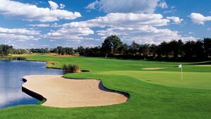 A golf course with a pond, sand bunkers, and a flag on the green. - Ringhotel Landhaus Gardels (Sankt Michaelisdonn)
