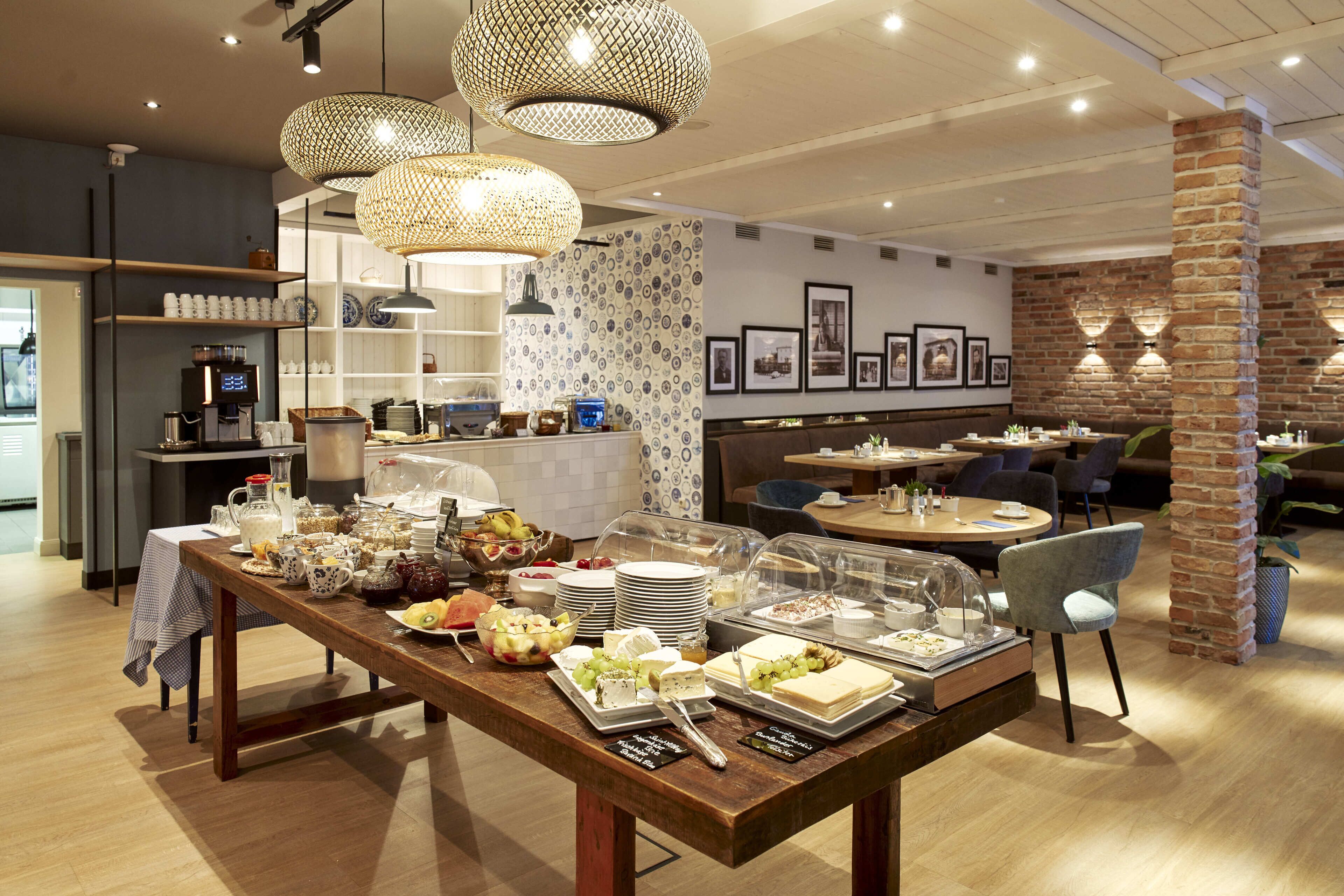A buffet setup with various food items and a seating area with tables and chairs.