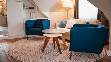 A modern living room with a sofa, two armchairs, a coffee table, and a lamp.