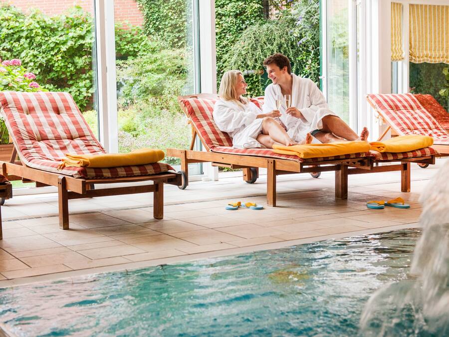 A poolside area with lounge chairs and a pool.