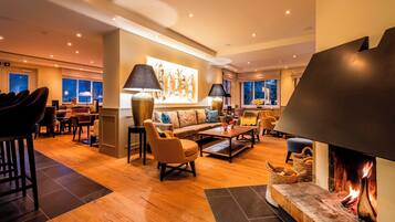 A modern living room with a fireplace, seating area, and a dining space.