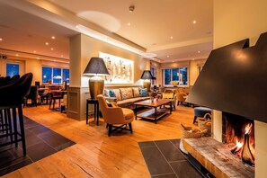 Una sala de estar moderna con chimenea, zona de estar y comedor.