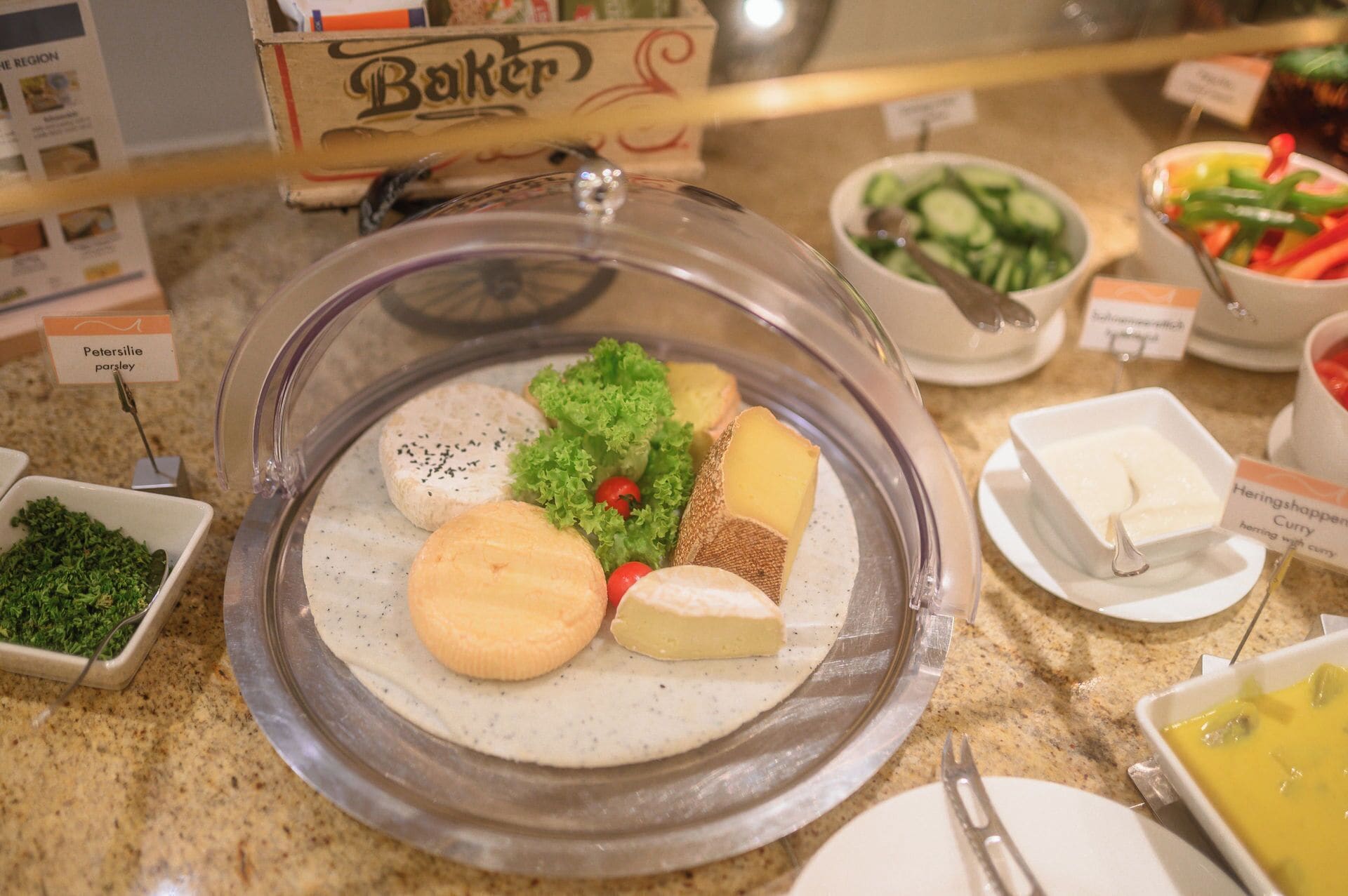 A buffet with various food items including cheese, lettuce, and a sign for 'Baker'.