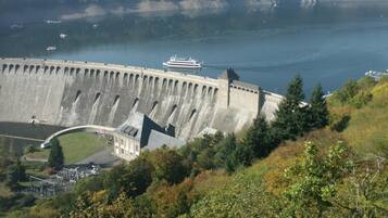 A large dam with a viewing platform and a building in the foreground.
