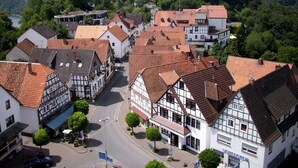 A traditional European town with timber-framed buildings, a central street, and a castle in the background. - Ringhotel Roggenland (Waldeck)