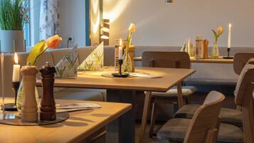 A dining area with tables, chairs, candles, and decorative items.