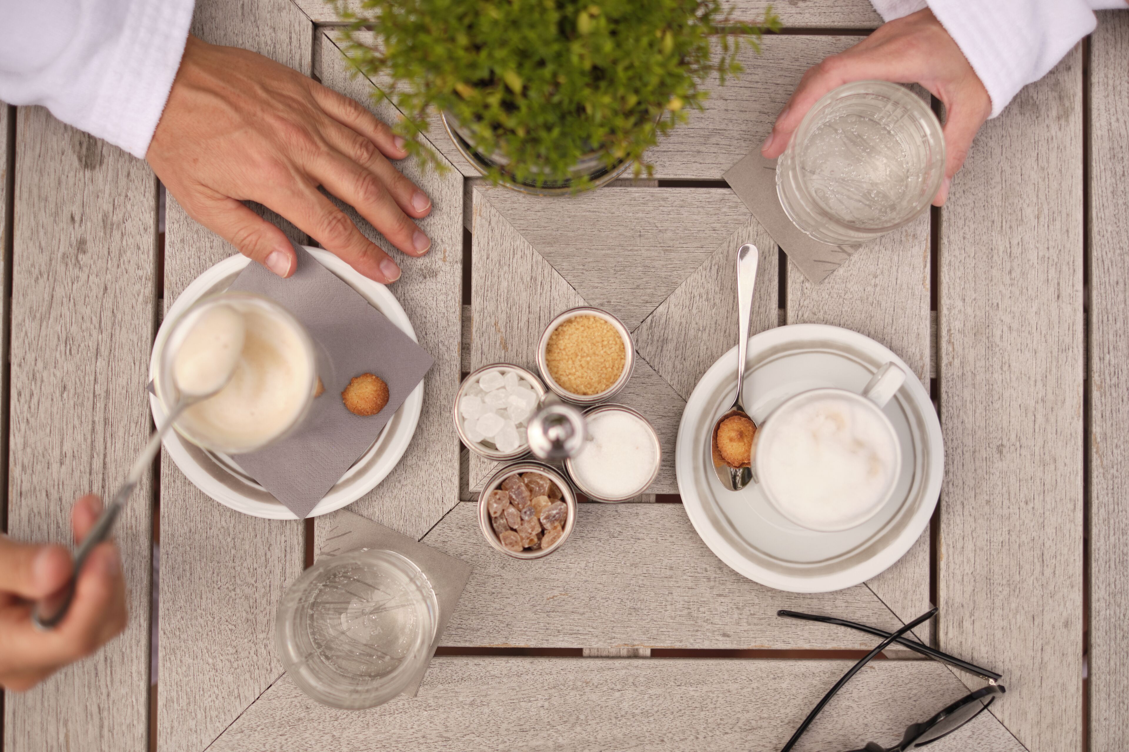 Une table sur laquelle se trouvent divers aliments et boissons, notamment un bol de soupe, une assiette de biscuits et une tasse de café.