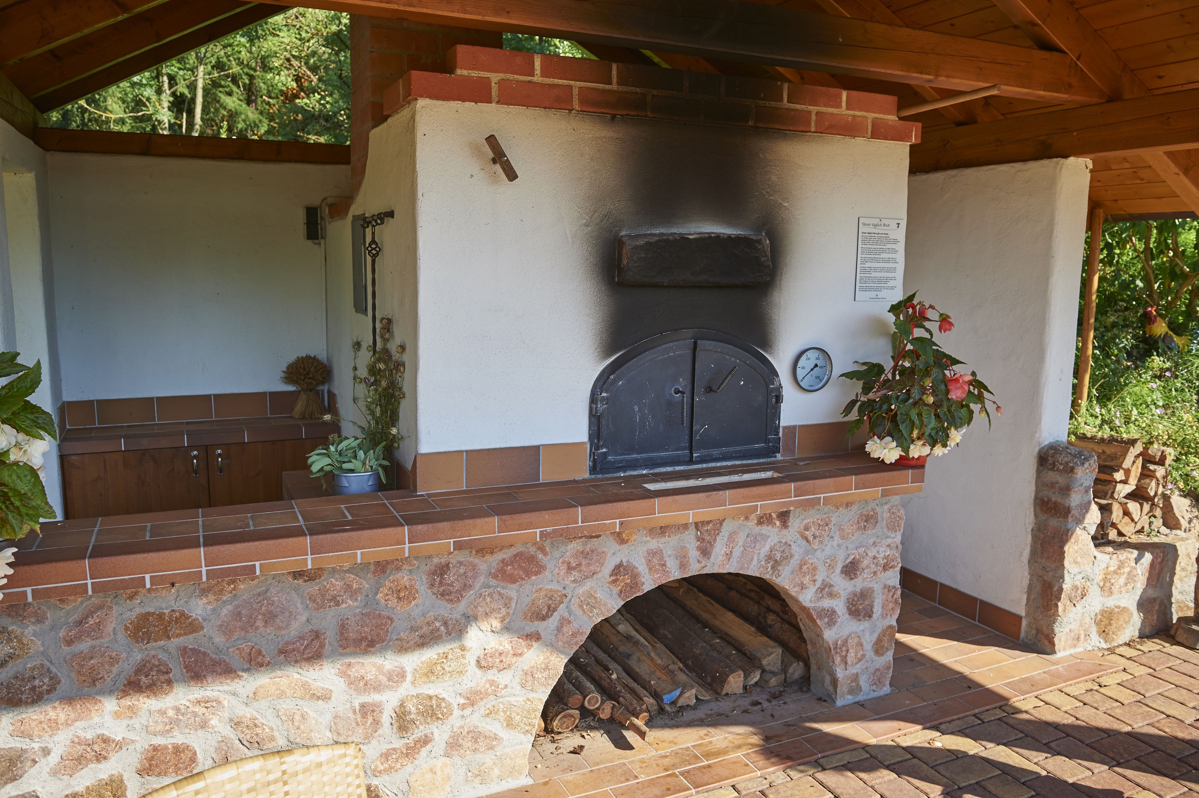 An outdoor kitchen with a stone arch and a brick counter.
