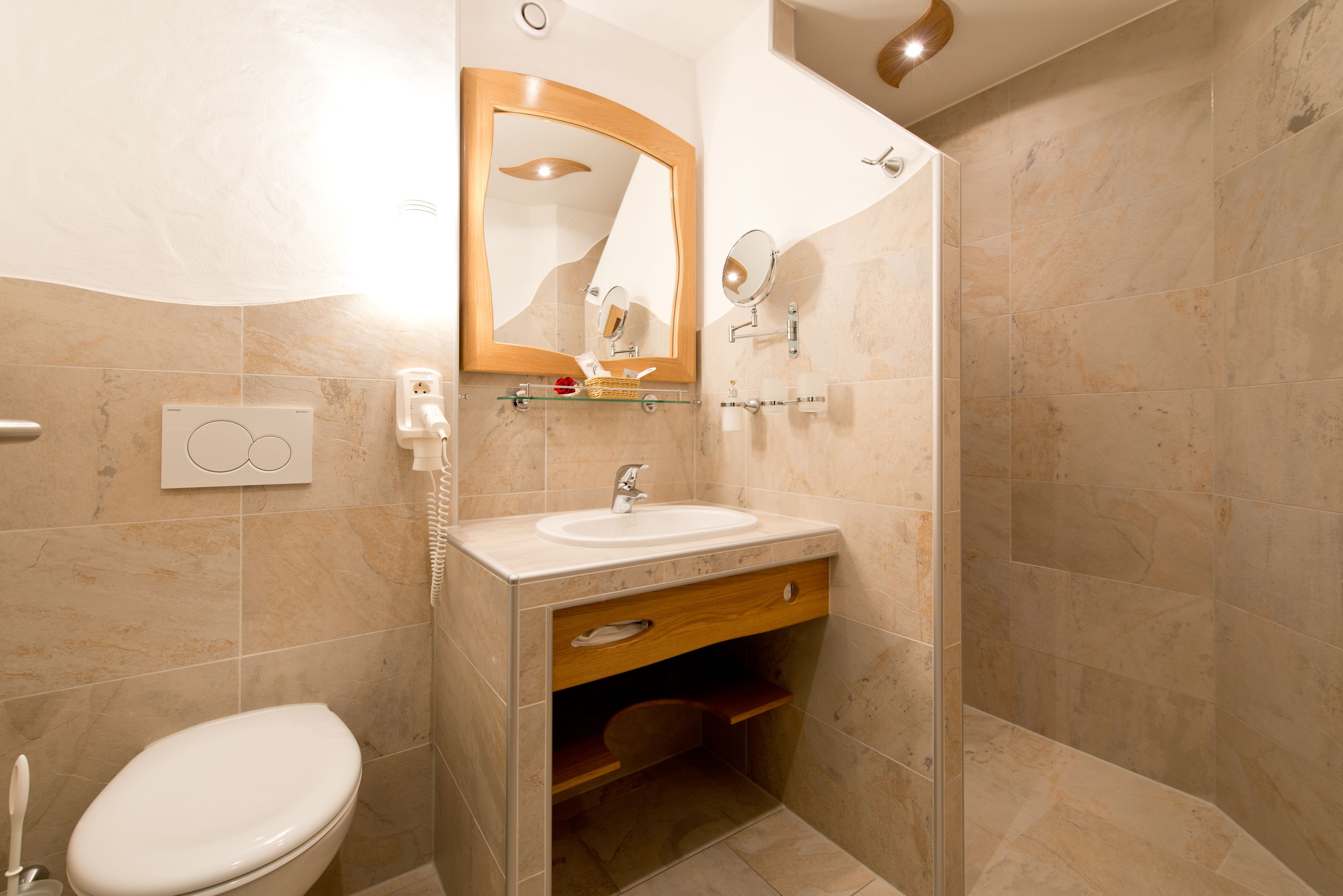 Une salle de bain comprenant des toilettes, un lavabo, un miroir et une douche.