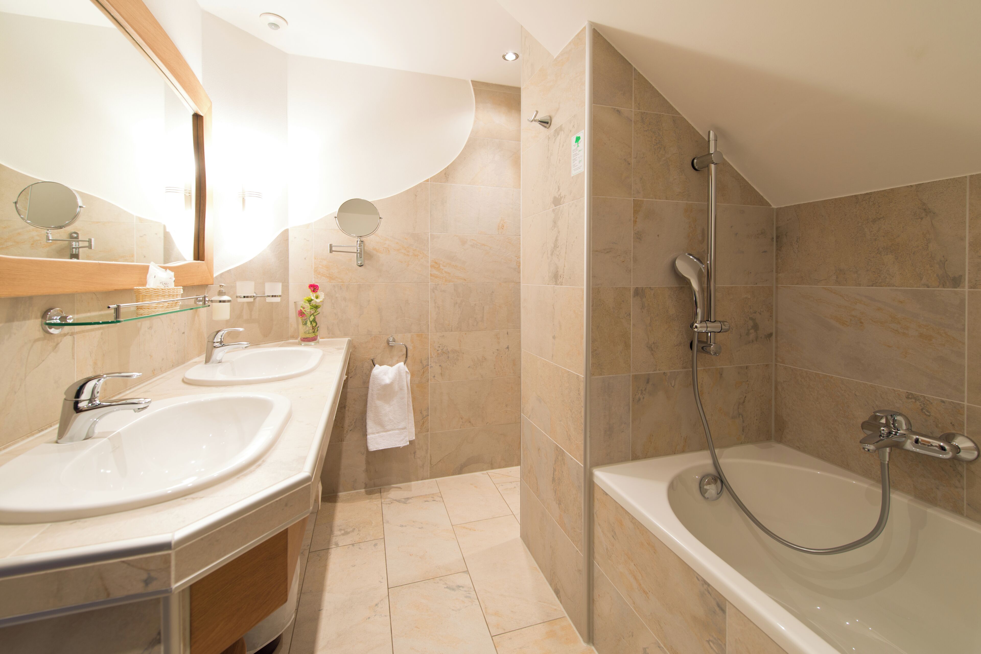 A modern bathroom with two sinks, a shower, and a bathtub.