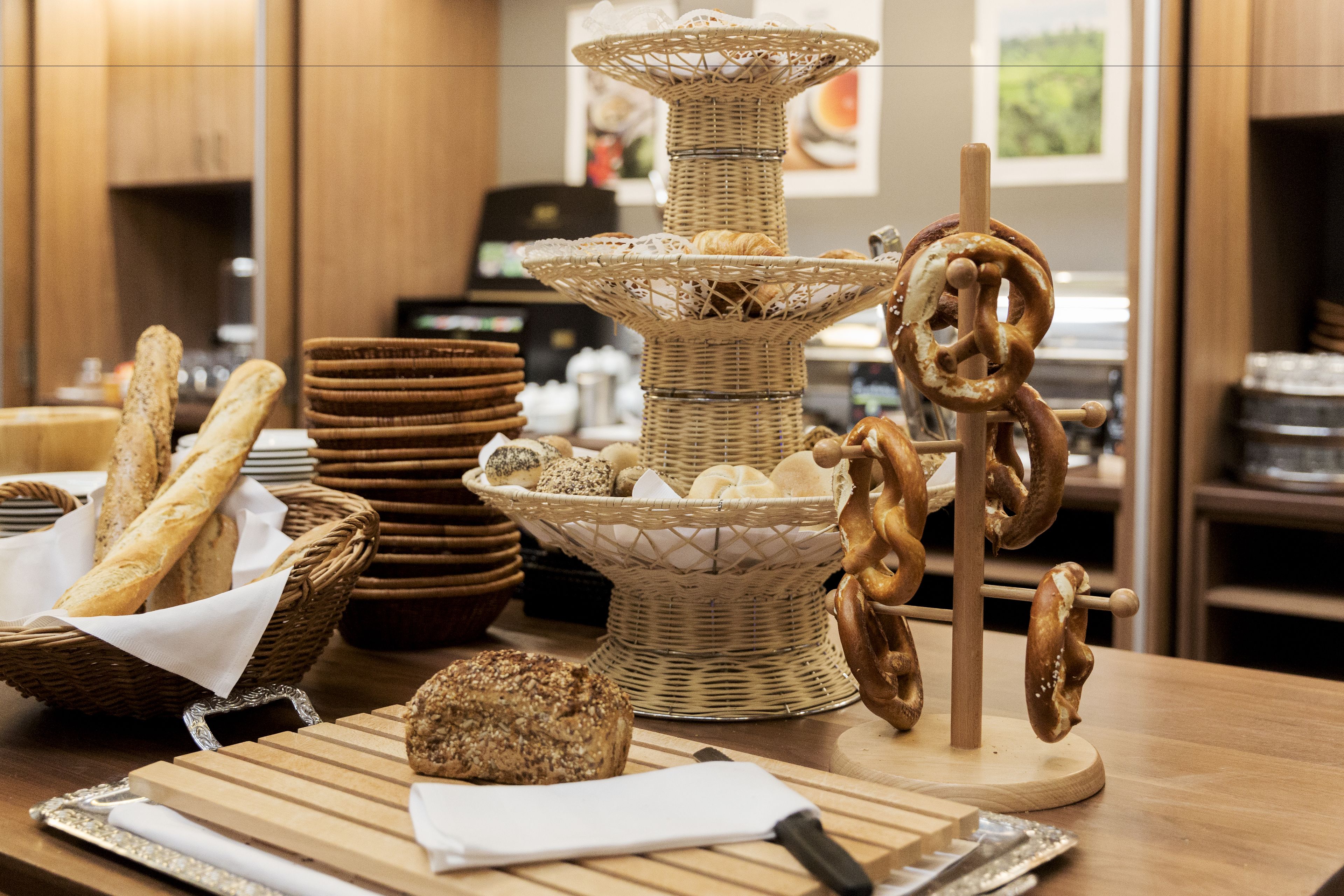 Una mesa de buffet con diversos panes, pasteles y pretzels.
