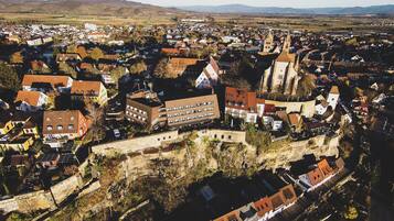 Ett flygbildsbild av en stad med historiska byggnader, en framträdande kyrka och en slottsliknande byggnad.