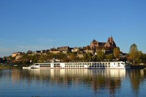 A riverboat with multiple decks, docked near a historic building with a prominent tower. - Hotel Stadt Breisach (Breisach)