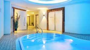 A spa area with a hot tub, a wooden door with 'DAMPFBAD' signage, and a tiled floor. - SEETELHOTEL Ostseehotel Ahlbeck (Heringsdorf)