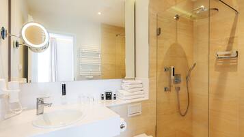 Ein modernes Badezimmer mit Waschbecken, Spiegel und Dusche.