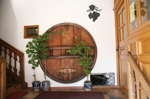 Paredes de barris de madeira com plantas em vasos, uma pequena janela e uma videira decorativa.