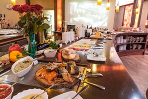 Enjoy a diverse spread of international cuisine at our restaurant, featuring a variety of fresh fruits, vegetables, and savory dips.