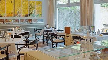 A restaurant with multiple tables, chairs, and a glass railing.