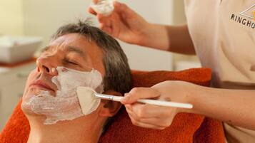 A person receiving a facial treatment with a brush.