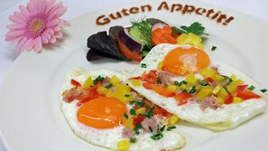 Two sunny-side-up eggs with diced vegetables on a white plate. - Hotel & Spa Sommerfeld - Adults Only (Kremmen)