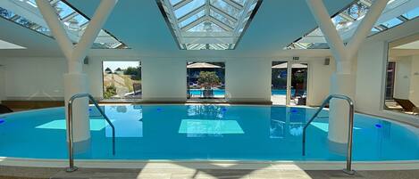Piscine couverte, piscine extérieure, parasols de plage, chaises longues