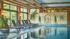 A pool area with lounge chairs, a fountain, and potted plants. - Ringhotel Mönchs Waldhotel (Unterreichenbach)