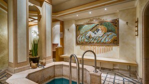 A luxurious indoor pool area with a marble floor, a large decorative mural, and a seating area with a bench. - Ringhotel Mönchs Waldhotel (Unterreichenbach)