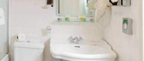 A small, clean bathroom with a toilet, sink, and mirror.