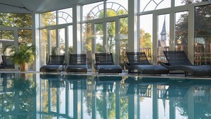 A pool with lounge chairs and a potted plant. - Das Palmenwald Schwarzwaldhof, BW Signature Collection (Freudenstadt)