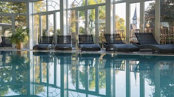 Una piscina techada, sillones reclinables de piscina