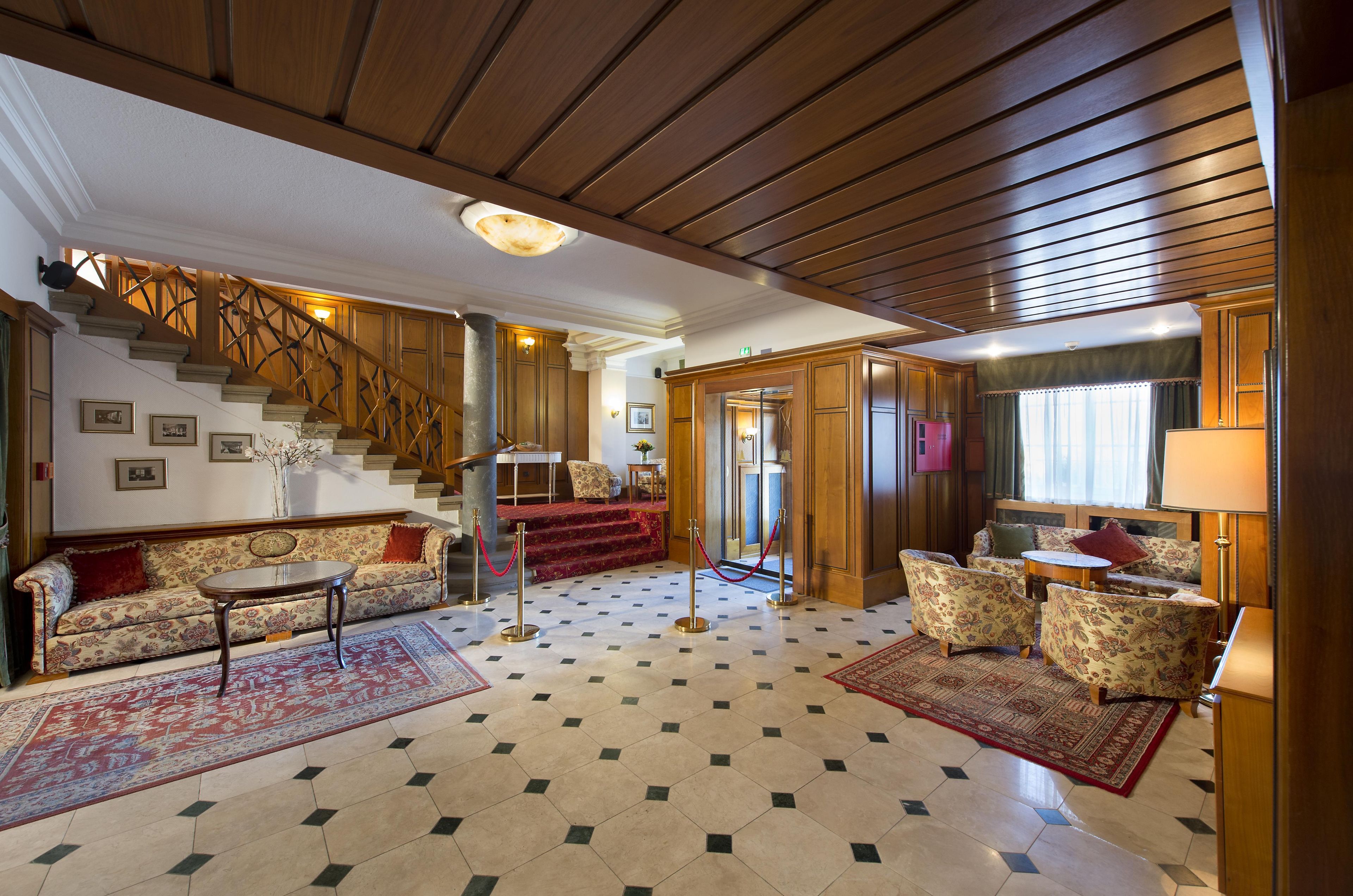A spacious living area with a staircase, a sofa set, and a dining table.