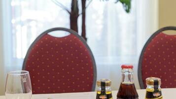 A table with a glass of white wine, a pen, and three bottles of beverages.