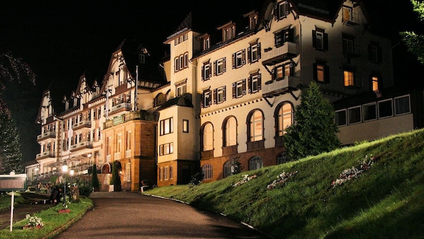 A large, historic building with multiple stories and balconies, a paved driveway, and a well-maintained lawn. - Das Palmenwald Schwarzwaldhof, BW Signature Collection (Freudenstadt)